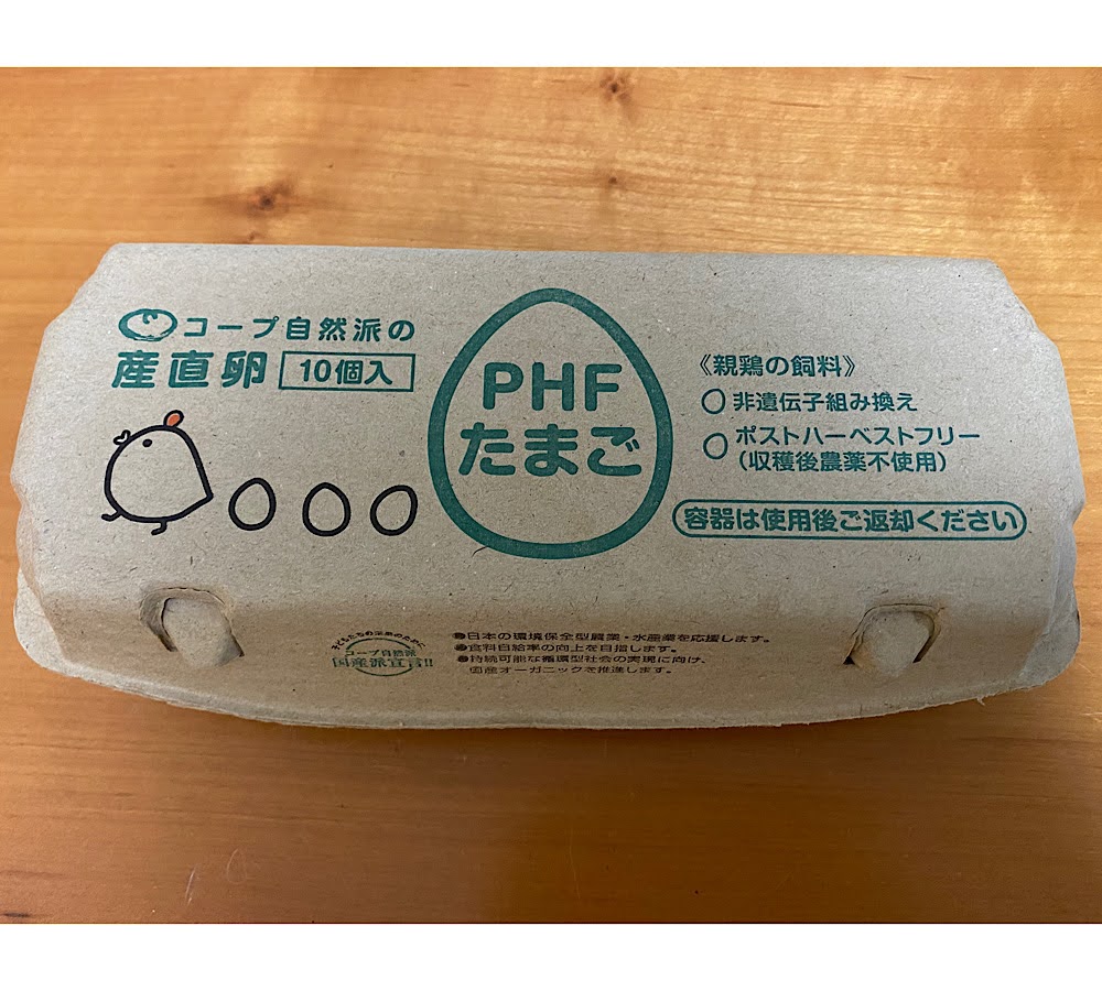 コープ自然派の産直卵「PHF白卵10個」の紙パック。非遺伝子組み換え・ポストハーベストフリーの表示