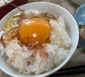 コープ自然派のPHF白卵を使った卵かけごはん。かつお節をのせた白いごはんに黄身がのっている