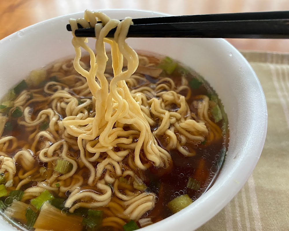 リニューアル後のベースラーメン鶏ガラ醤油ラーメンの麺を箸で持ち上げたところ