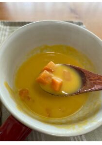 SONOKOの北海道にんじんポタージュをスプーンですくった様子。角切りのにんじんがゴロッと入っている