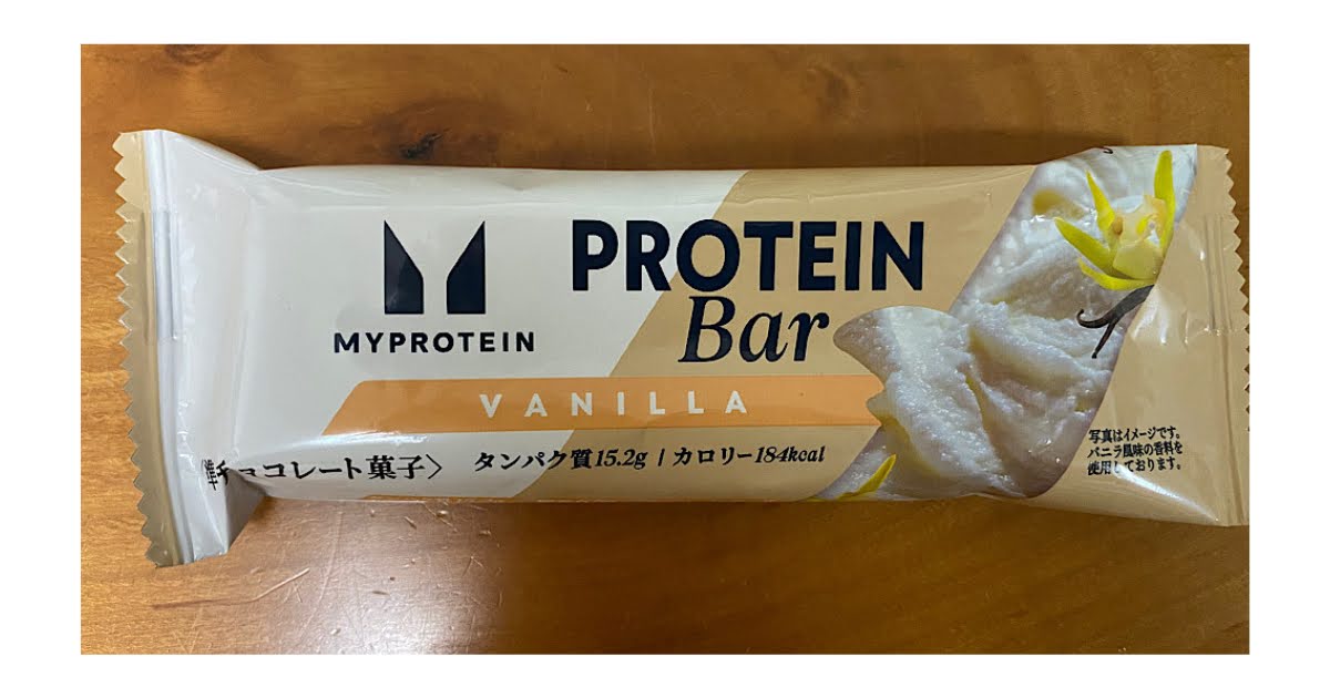 マイプロテイン プロテインバー バニラ風味のパッケージ。木のテーブルの上に置いた写真